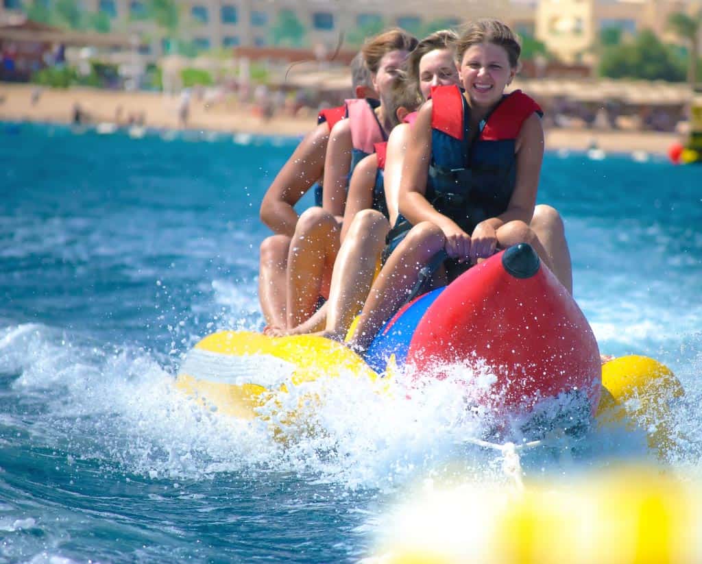 banana-boat-ride-more-than-just-fun-and-adventure a girl riding a wave on a surfboard in the water