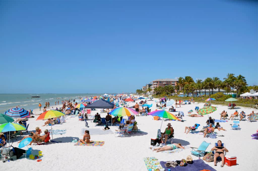 a group of people sitting at a crowded beach
