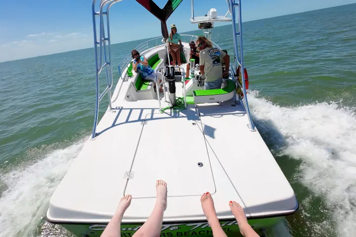View of people on a boat at sea with feet visible in the foreground.