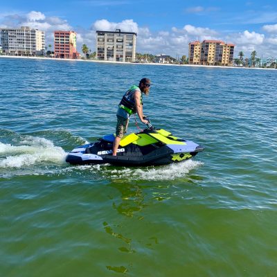 a man riding on the back of a boat in the water