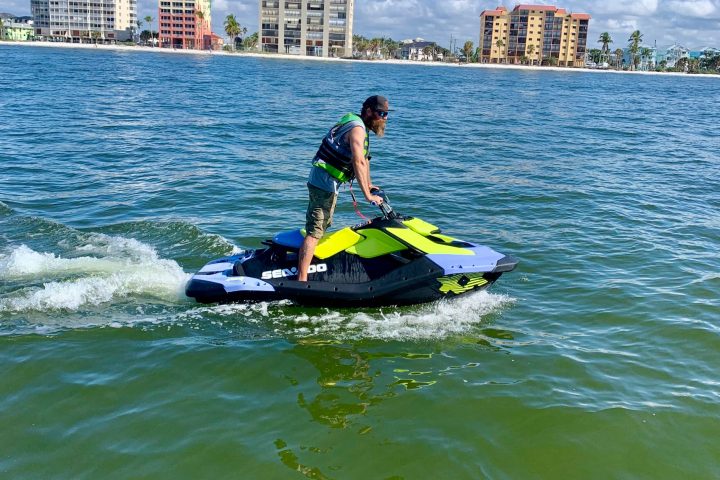 a man riding on the back of a boat in the water